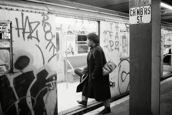 A passenger boards a subway car painted with graffiti in 1984.